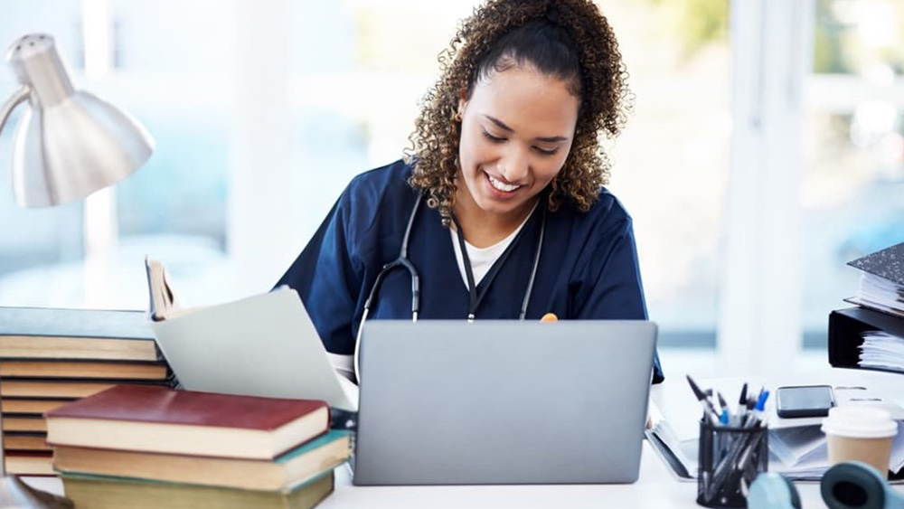 An RN studies with her laptop to earn her BSN